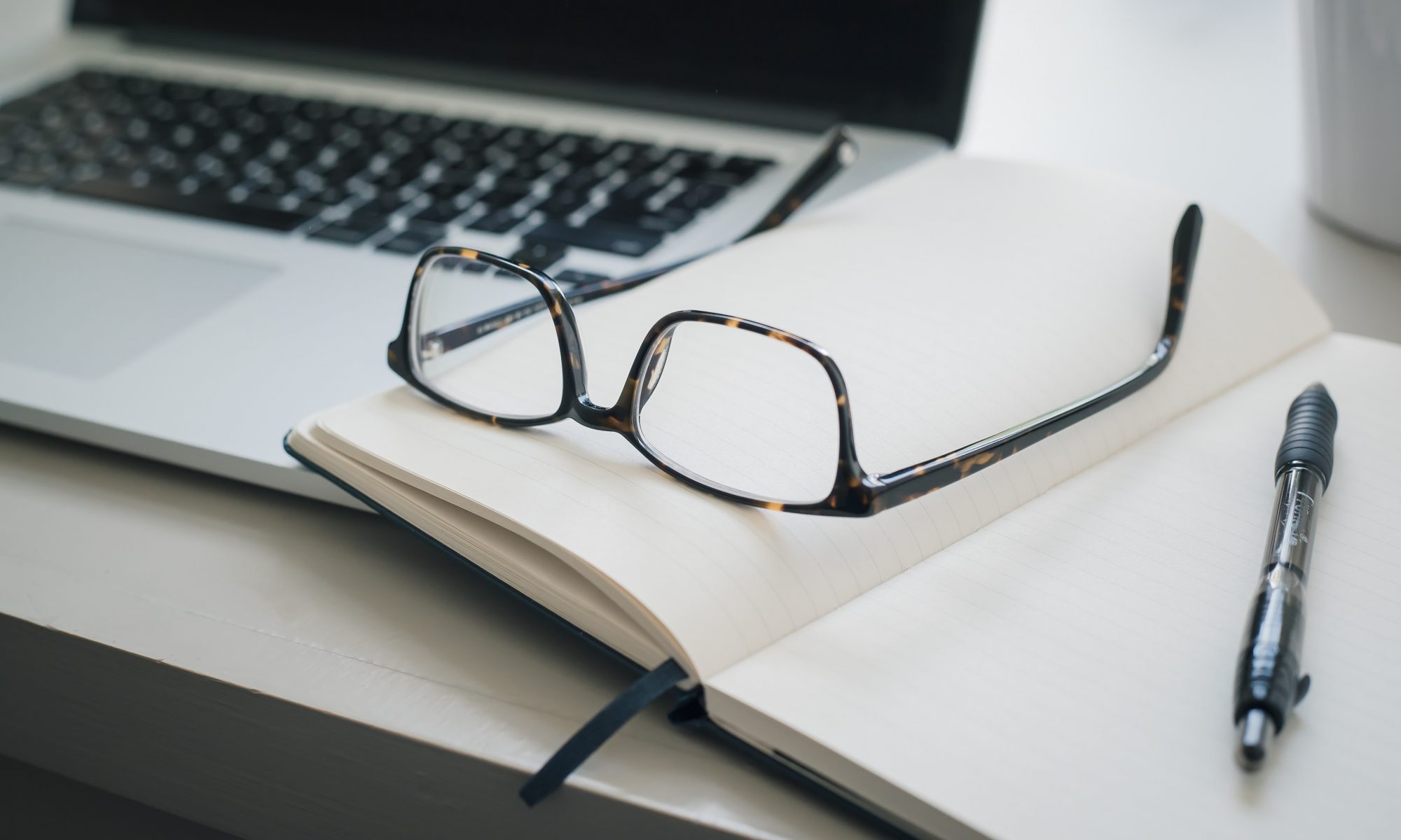 black framed eyeglasses and black pen